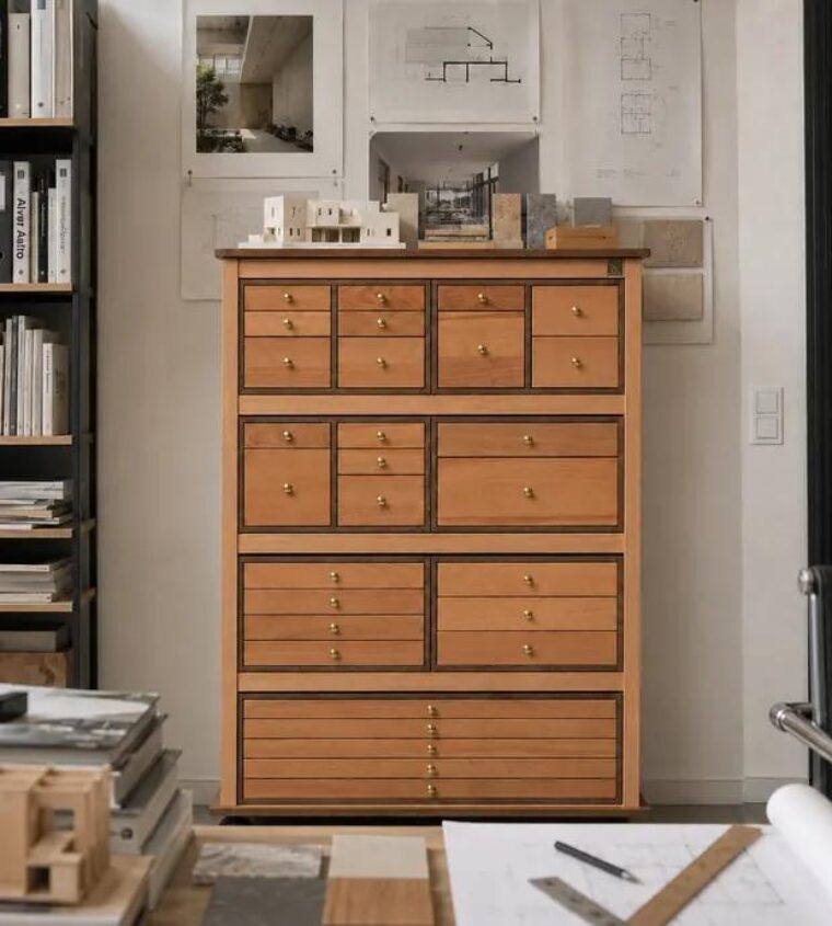 Commode à tiroirs Auboi dans un cabinet d’architecture, maquettes de papier posées sur son plateau, plans punaisés au mur