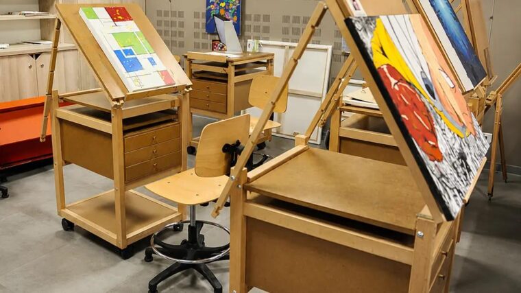 Tables à dessin Auboi inclinables sur roulettes dans un atelier créatif Cultura, travaux en cours posés sur les plateaux, tabouret d’atelier entre deux postes