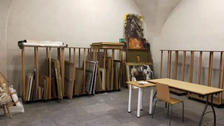 Réserve voûtée de la Ville d’Issoire : râteliers à toiles Auboi chargés de tableaux encadrés, rangés sur la tranche le long des murs
