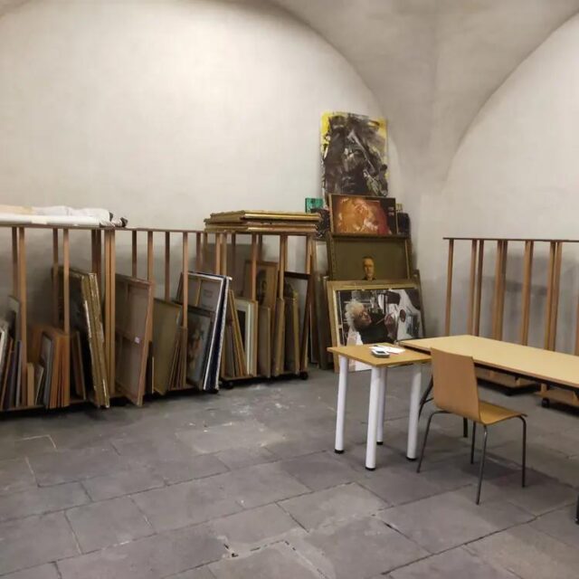 Réserve voûtée de la Ville d’Issoire : râteliers à toiles Auboi chargés de tableaux encadrés